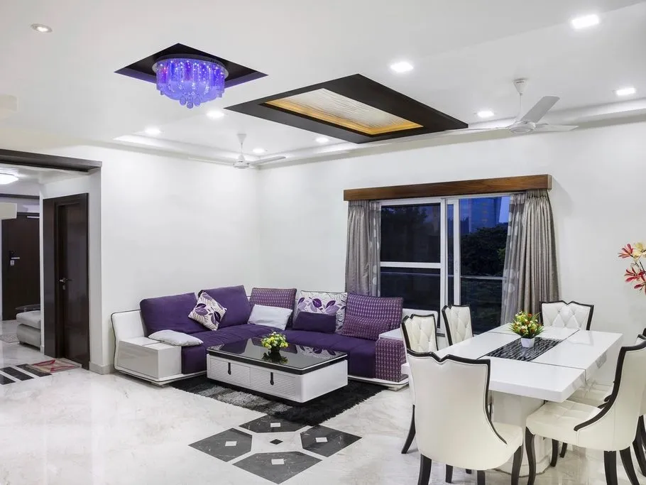 Phòng khách sáng với đèn âm trần và trần giật cấp